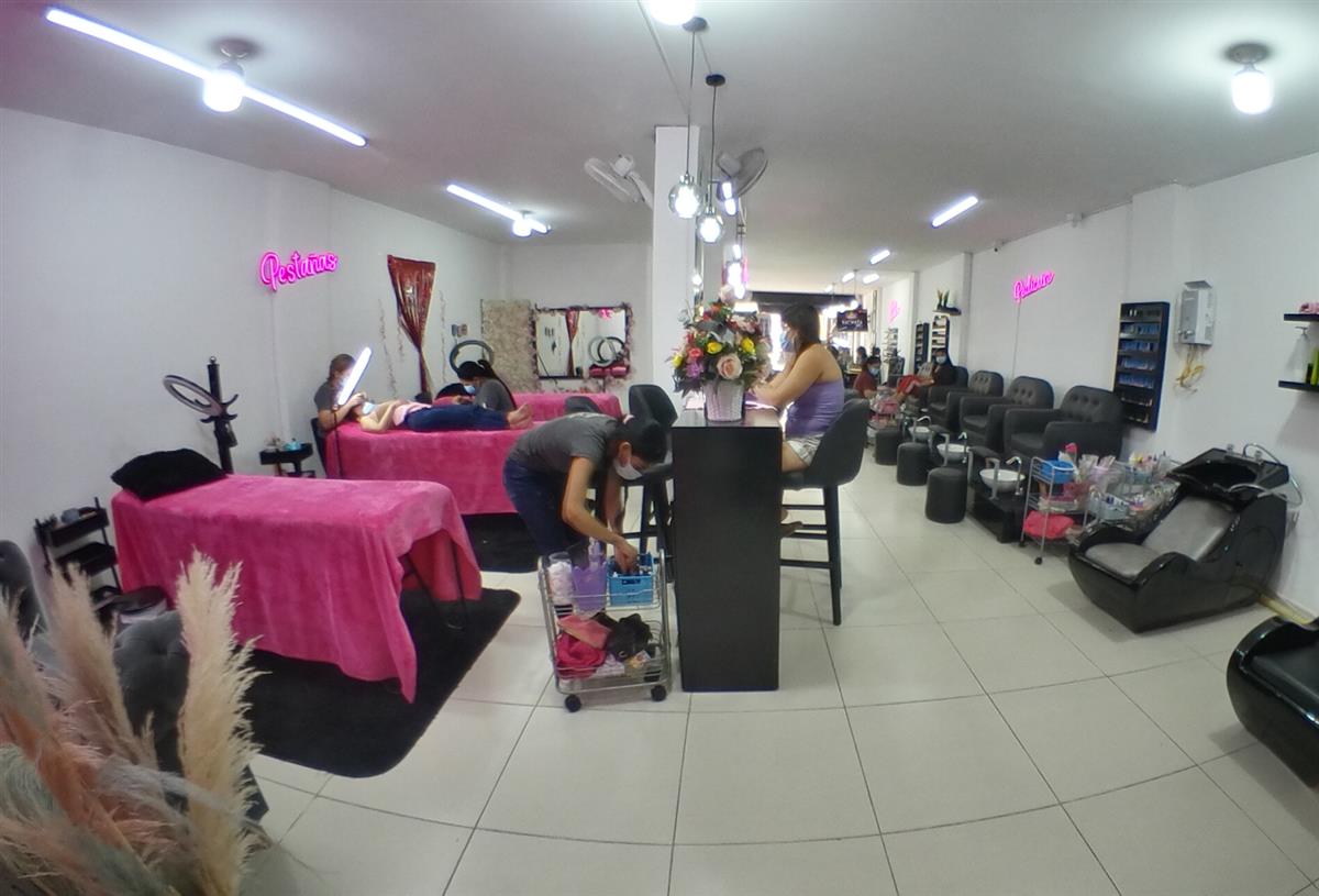 Interior del salón de Uñas Pao con mesas fucsia y luces de neón